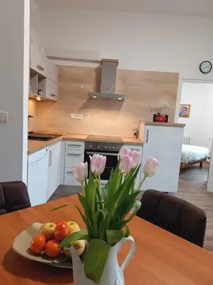 a kitchen with a table with a vase of flowers on it at Apartma Mjrka in Dobrovo
