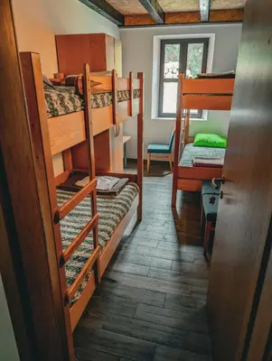 a room with three bunk beds and a door at Dom dr Klementa Juga v Lepeni in Soča
