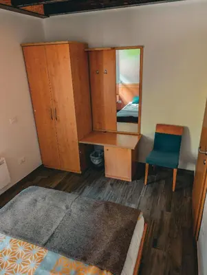 a bedroom with a desk and a mirror and a chair at Dom dr Klementa Juga v Lepeni in Soča