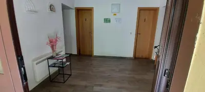 a hallway with two doors and a vase on a table at Dom dr Klementa Juga v Lepeni in Soča