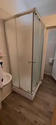 a glass shower in a bathroom with a toilet at Dom dr Klementa Juga v Lepeni in Soča