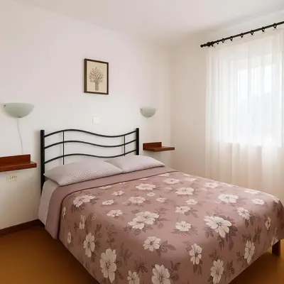 a bedroom with a bed with a brown and white blanket at Hiša Vanda in Dobrovo