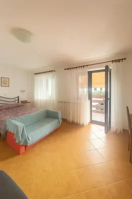 a bedroom with a bed and a sliding glass door at Hiša Vanda in Dobrovo