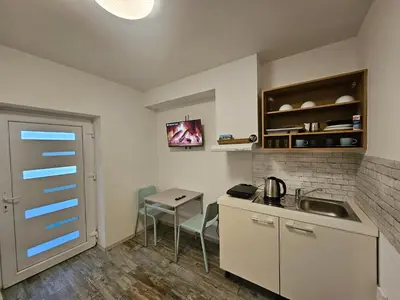 a small kitchen with a sink and a table at Apartman min & Ljubljana in Ljubljana