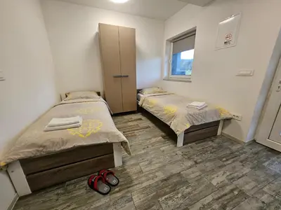 a room with two beds and a window at Apartman min & Ljubljana in Ljubljana