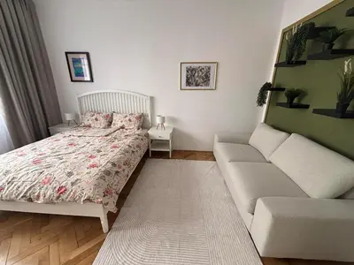 a bedroom with a bed and a couch at Trina apartment in the city centre in Ljubljana