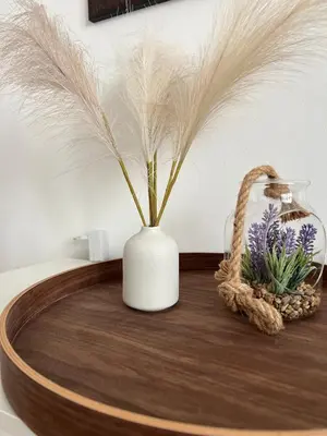 a white vase with feathers and a basket on a table at Trina apartment in the city centre in Ljubljana