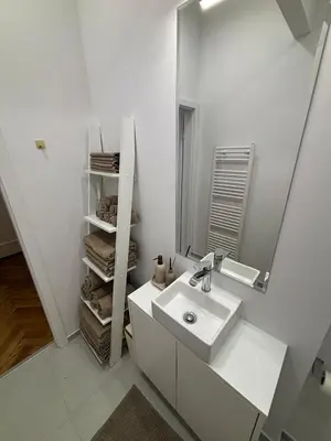 a white bathroom with a sink and a mirror at Trina apartment in the city centre in Ljubljana