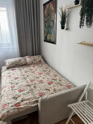 a small bedroom with a bed with a quilt on it at Trina apartment in the city centre in Ljubljana