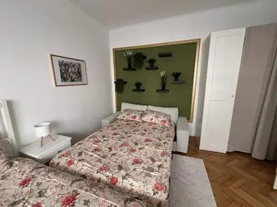 a bedroom with a bed with a flowered comforter at Trina apartment in the city centre in Ljubljana