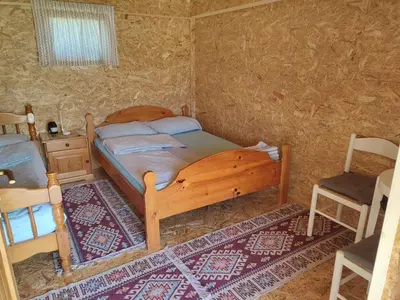 a bedroom with a wooden bed and a chair at Rustic glamping on a farm in Radovljica