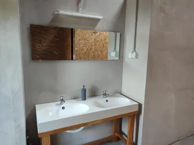 a bathroom with a white sink and a mirror at Rustic glamping on a farm in Radovljica