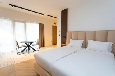 a bedroom with a large white bed and a table at Soho Boutique apartments in Ljubljana