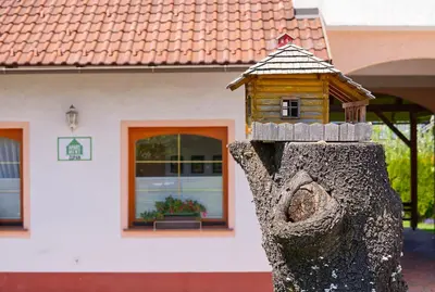 a bird house sitting on top of a tree stump at Apartment Zupan in Begunje na Gorenjskem