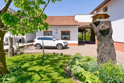 a car parked in front of a house with a statue at Apartment Zupan in Begunje na Gorenjskem