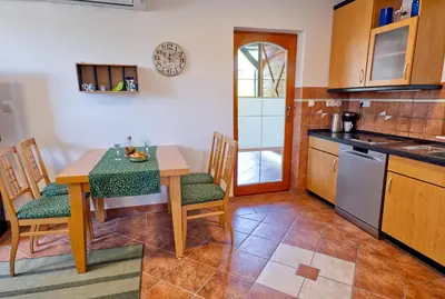 a kitchen with a table and chairs and a kitchen with a counter at Apartment Zupan in Begunje na Gorenjskem