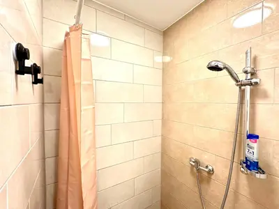 a shower with a shower curtain in a bathroom at Rookos rooms in Ljubljana