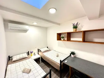 a room with two beds and a table at Rookos rooms in Ljubljana