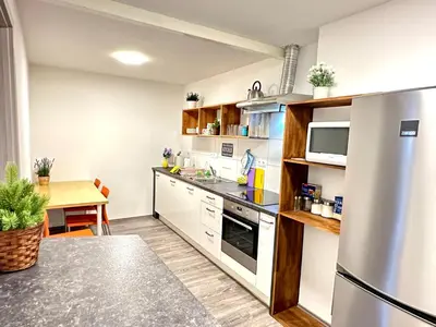 a kitchen with white cabinets and a stainless steel refrigerator at Rookos rooms in Ljubljana