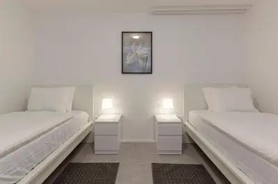 two beds in a room with two nightstands at Serenity Apartment Bled - New, Stylish, Near Lake in Bled