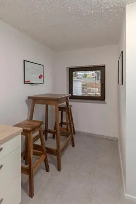 a kitchen with two stools and a table and a window at Serenity Apartment Bled - New, Stylish, Near Lake in Bled