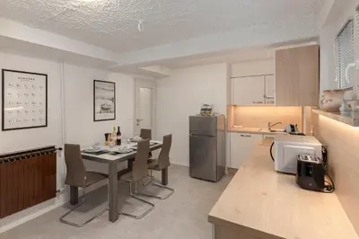 a kitchen with a table and chairs and a refrigerator at Serenity Apartment Bled - New, Stylish, Near Lake in Bled