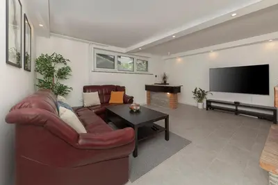 a living room with a couch and a flat screen tv at Serenity Apartment Bled - New, Stylish, Near Lake in Bled