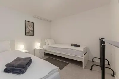 a white bedroom with two beds and two lamps at Serenity Apartment Bled - New, Stylish, Near Lake in Bled