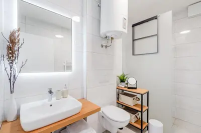 a white bathroom with a sink and a toilet at Skalja Apartment in Bovec