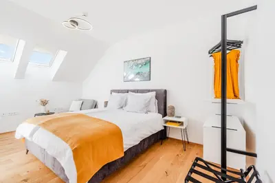 a bedroom with a large bed with white walls at Skalja Apartment in Bovec