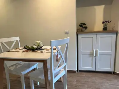 a dining room table with two chairs and a table and a cabinet at Apartment Abinkar in Tolmin