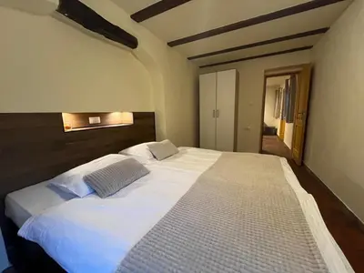 a bedroom with a large bed with white sheets at Apartment Abinkar in Tolmin