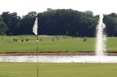 a fountain in the middle of a golf course with a pond at Apartment HB Moravske Toplice in Moravske Toplice