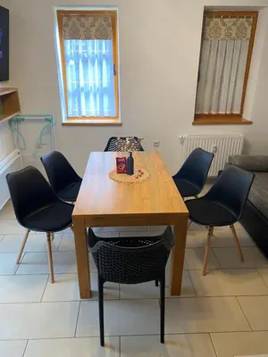 a wooden table and chairs in a room at Apartment HB Moravske Toplice in Moravske Toplice