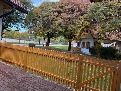 a wooden fence in front of a house with trees at Apartment HB Moravske Toplice in Moravske Toplice