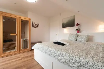 a bedroom with a bed and a tv on the wall at Deer Land Photo Apartment in Kočevska Reka