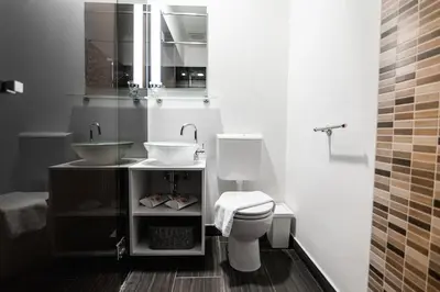 a white bathroom with a sink and a toilet at Oxford Apartments in Ljubljana