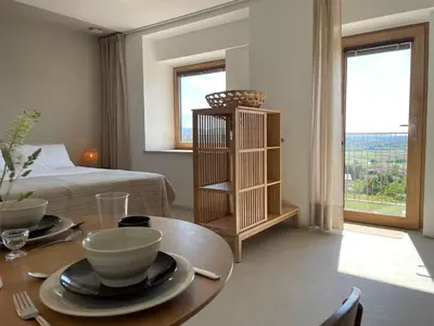 a living room with a table and a bed at Vipava View Studio Apartments in Šempas