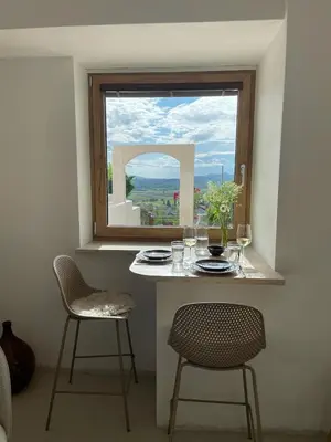 a table and two chairs in a room with a window at Vipava View Studio Apartments in Šempas
