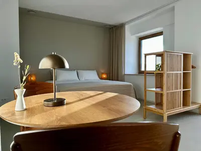 a bedroom with a table and a bed and a bed at Vipava View Studio Apartments in Šempas
