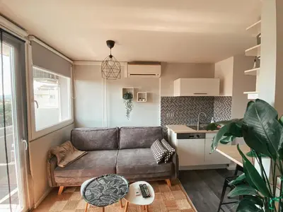 a living room with a couch and a kitchen at Charming Apartment Siska in Ljubljana