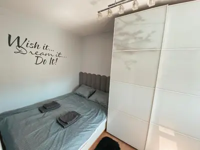 a bedroom with a bed and a wall with a mirror at Charming Apartment Siska in Ljubljana