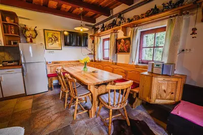 a kitchen with a wooden table and a refrigerator at Kaval Home with Free Onsite Wellness in Dravograd