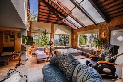 a living room with a couch and a tub at Kaval Home with Free Onsite Wellness in Dravograd