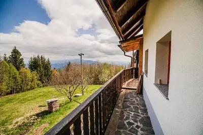 a balcony of a house with a view of the mountains at Kaval Home with Free Onsite Wellness in Dravograd