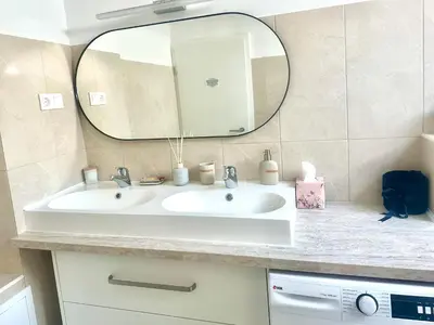 a bathroom with a white sink and a mirror at Sunny 3-room apartment with a terrace in Ljubljana