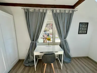 a desk and a chair in a room with a window at Sunny 3-room apartment with a terrace in Ljubljana