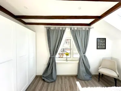 a room with a window with curtains and a chair at Sunny 3-room apartment with a terrace in Ljubljana
