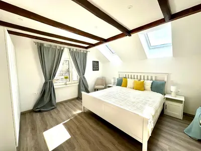 a bedroom with a white bed and a window at Sunny 3-room apartment with a terrace in Ljubljana