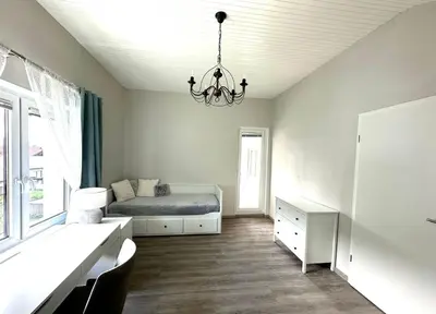 a bedroom with a bed and a chandelier at Sunny 3-room apartment with a terrace in Ljubljana